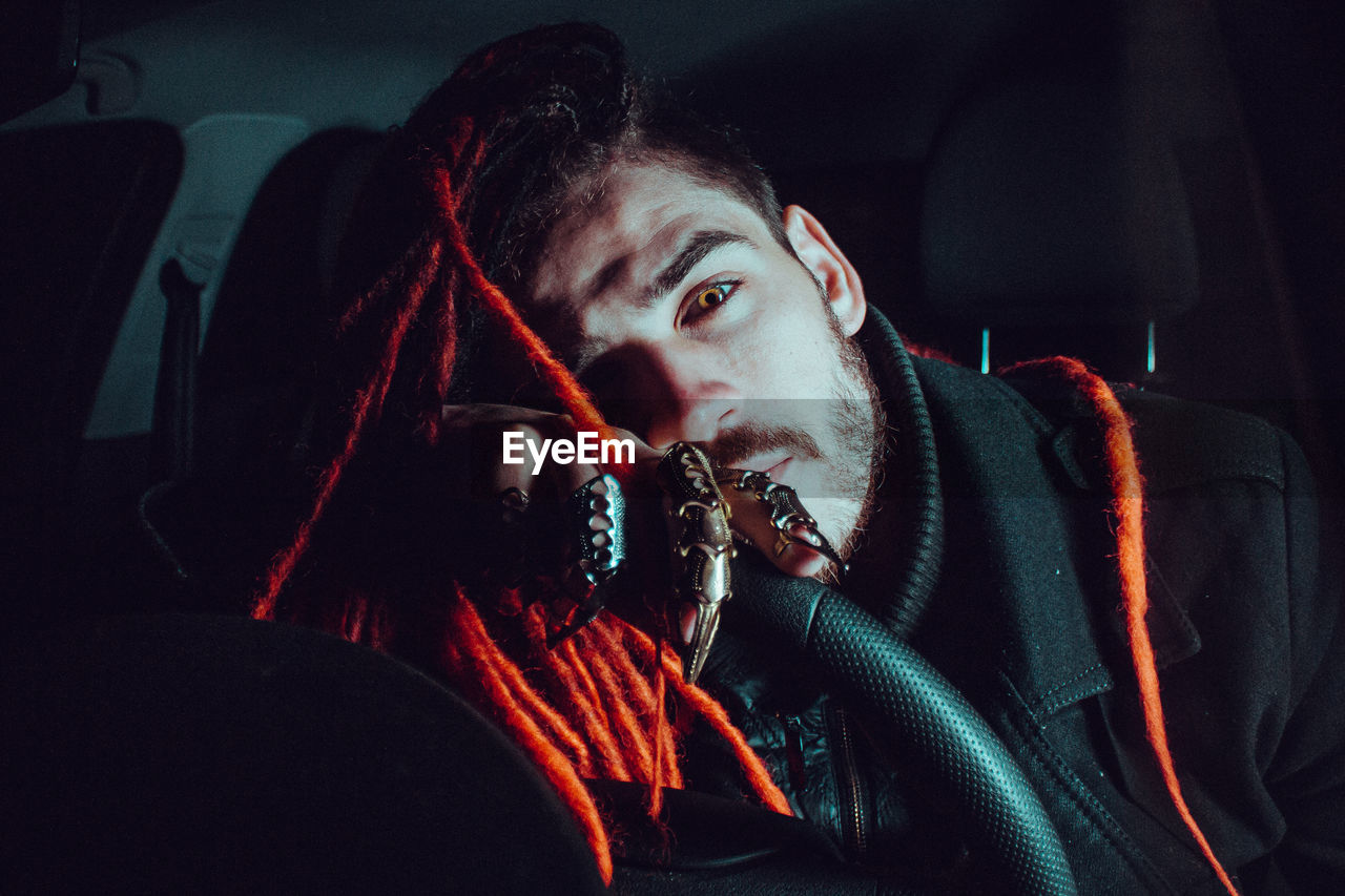 Portrait of young man with spooky eyes in car