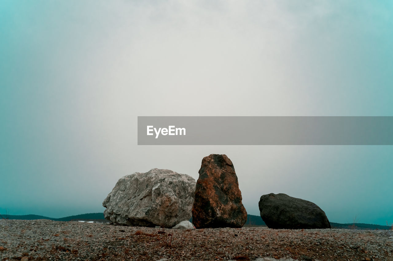 Rocks on sea shore against sky