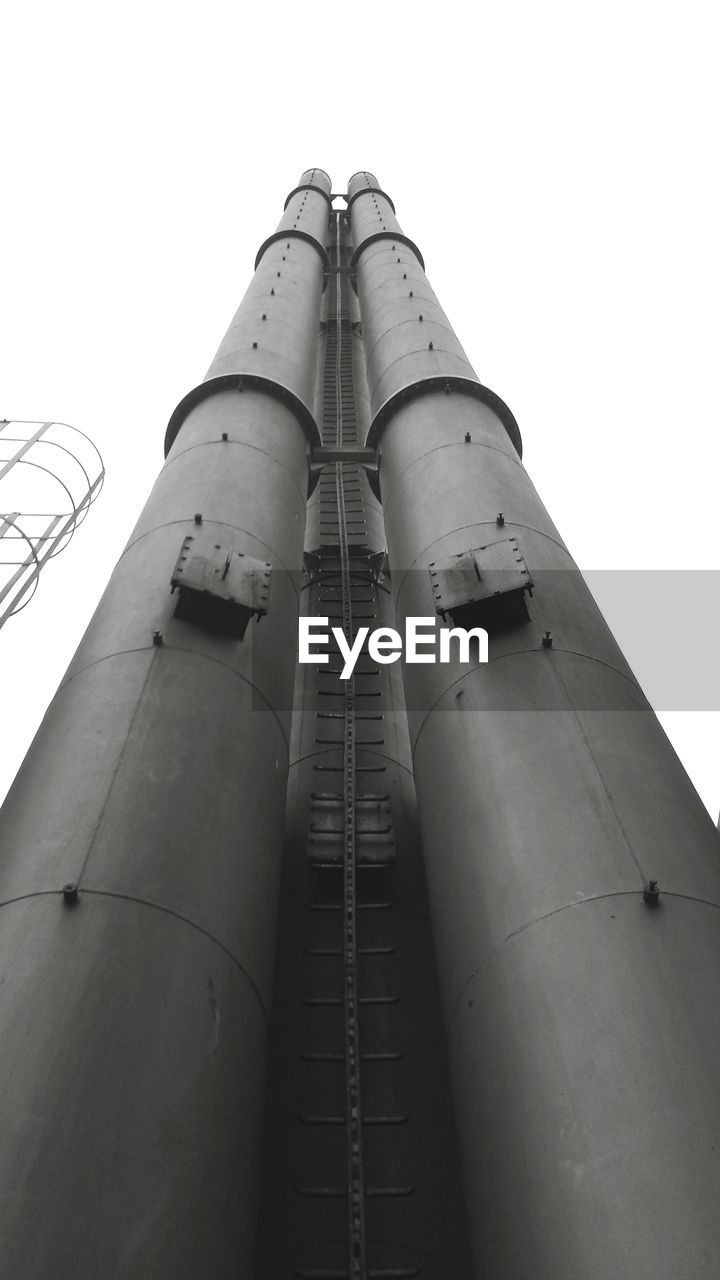 Low angle view of smokestack against clear sky