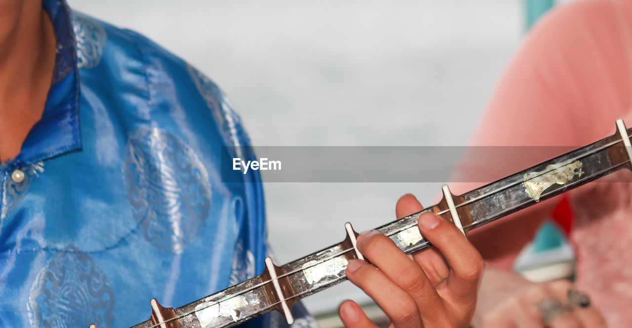 Close-up of man playing guitar