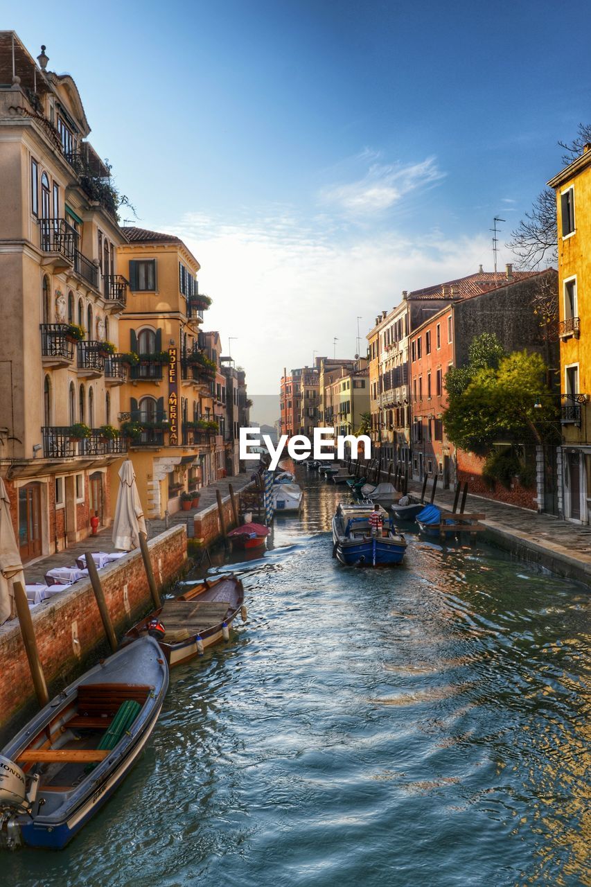 High angle view of boats on canal amidst buildings