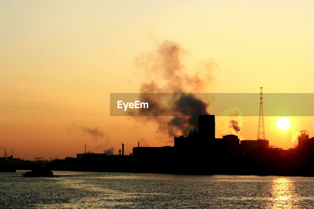 SMOKE EMITTING FROM CHIMNEY IN RIVER AGAINST SKY