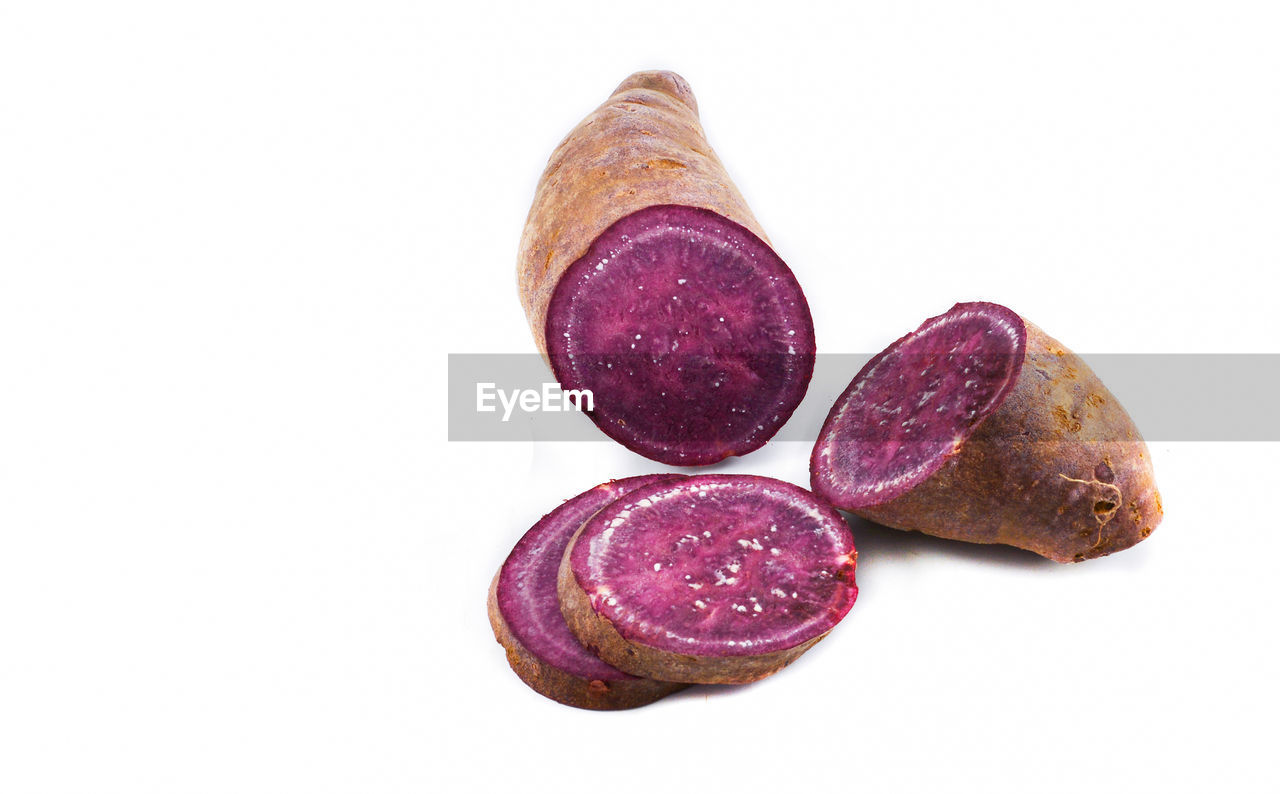 CLOSE-UP OF FRESH PINK FRUITS OVER WHITE BACKGROUND