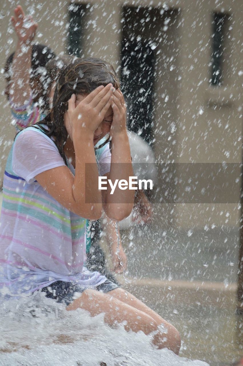 Girl sitting by fountain