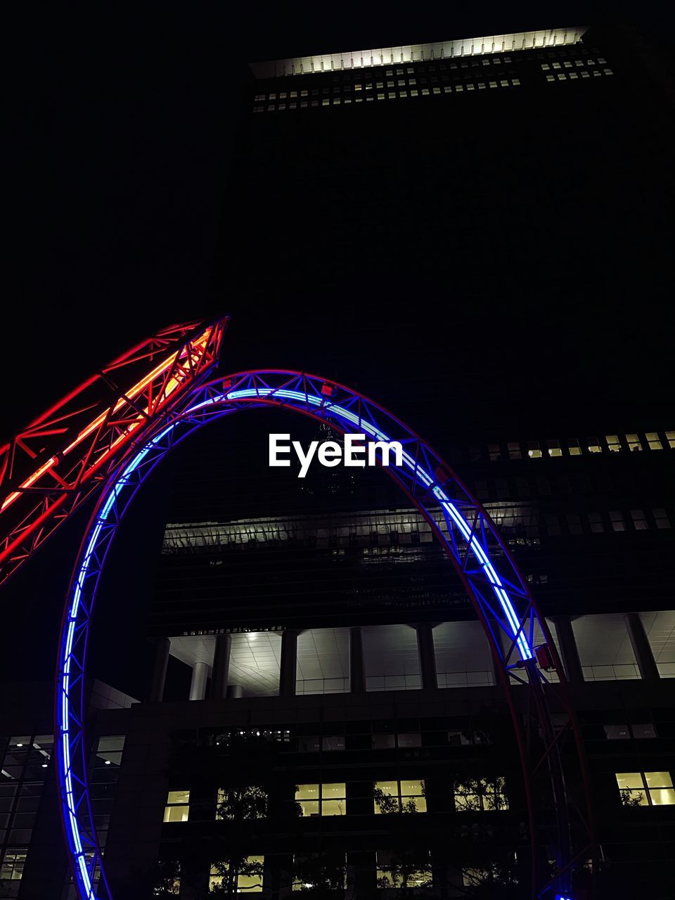 LOW ANGLE VIEW OF LIGHT TRAILS ON BRIDGE AGAINST SKY