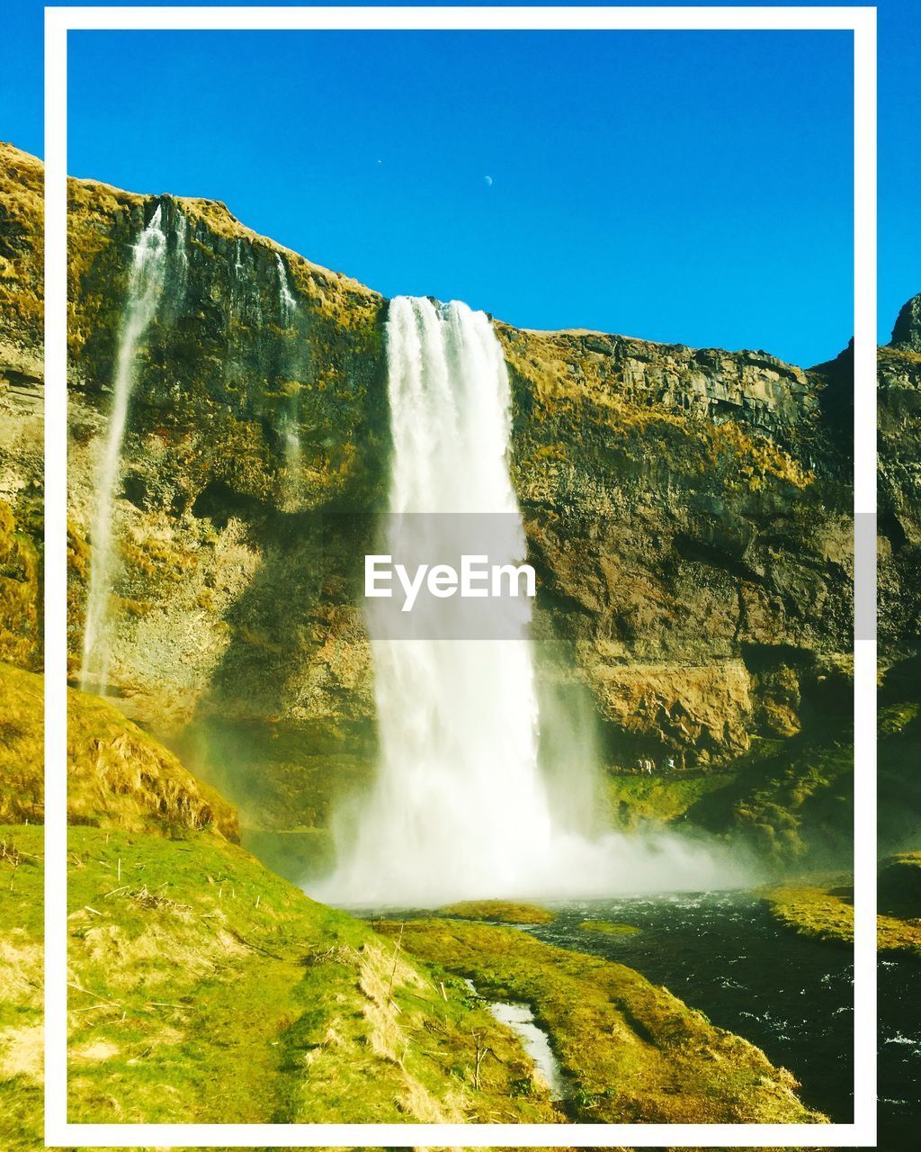 SCENIC VIEW OF WATERFALL IN FOREST AGAINST SKY