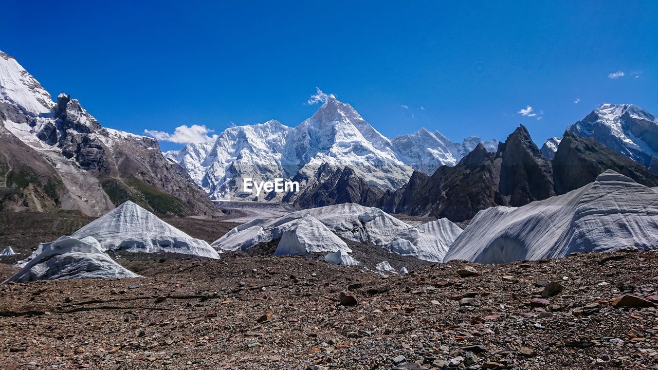 Scenic view of snowcapped mountains against blue sky