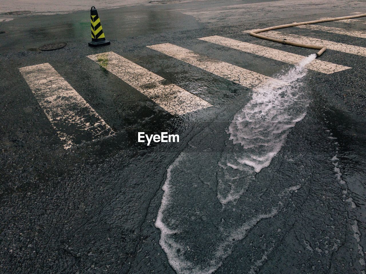 High angle view of water flowing through pipe on road