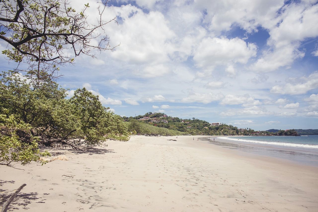 Scenic view of beach against cloudy sky