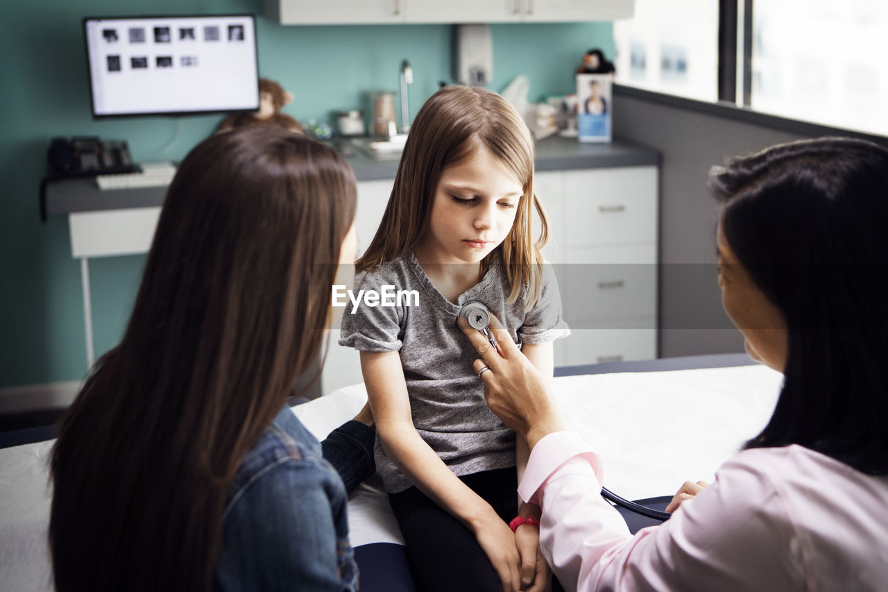 Girl being examined by female doctor in clinic