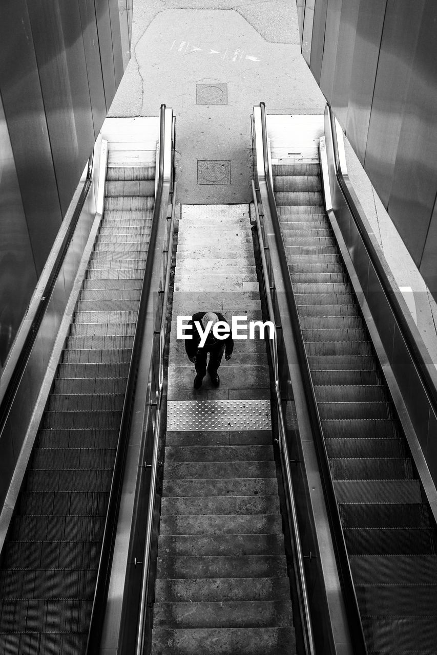 High angle view of man standing on escalator