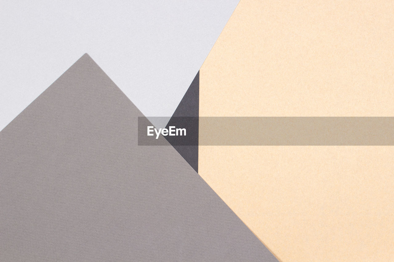 Abstract geometric paper background light gray, black colors and brown craft paper. top view