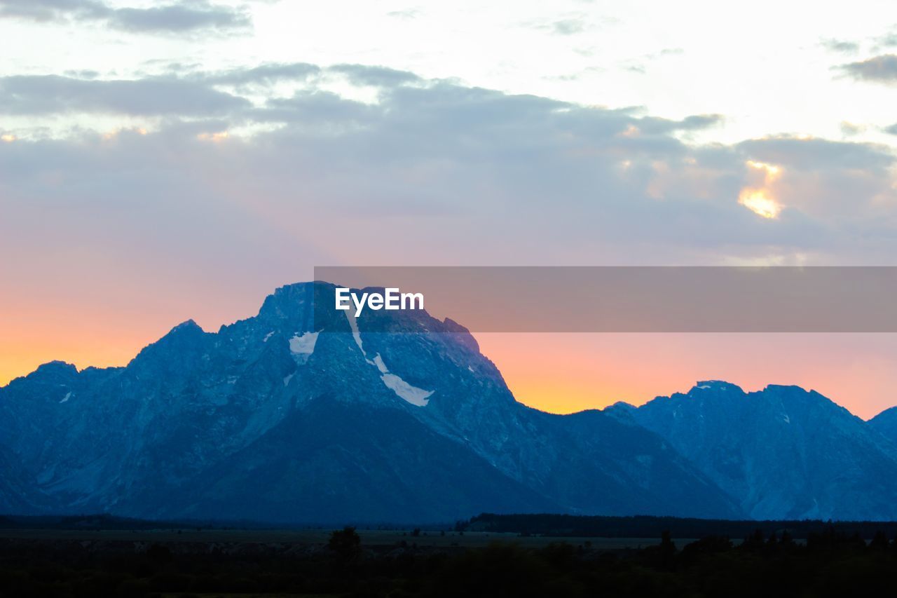 SCENIC VIEW OF SNOW COVERED MOUNTAINS AT SUNSET