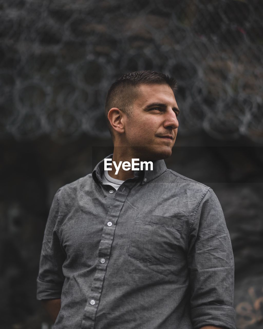 Front view of man looking away while standing outdoors