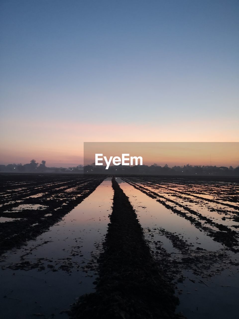 CANAL AMIDST FIELD AGAINST SKY AT SUNSET