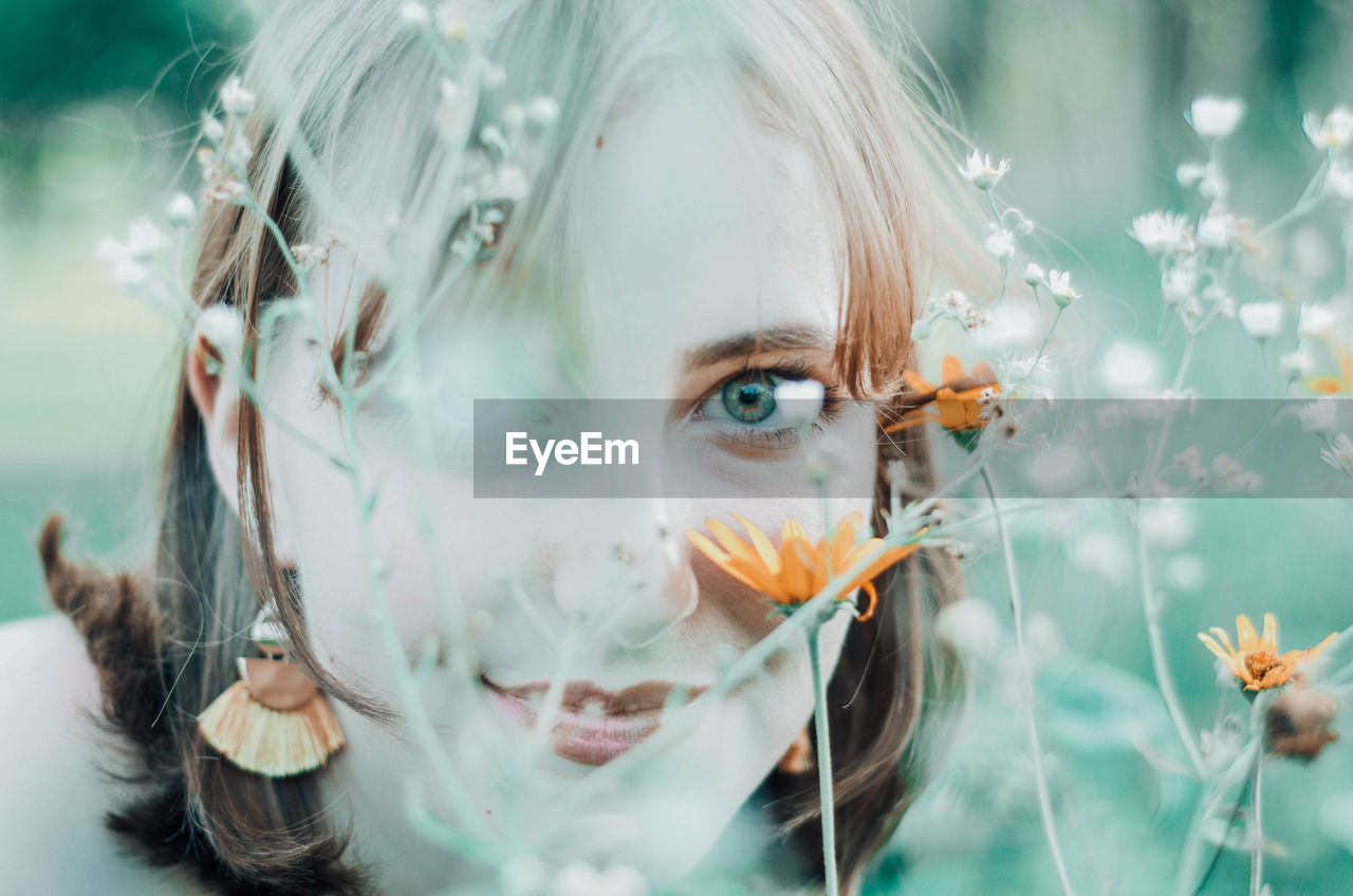 Close-up of beautiful woman looking through plants