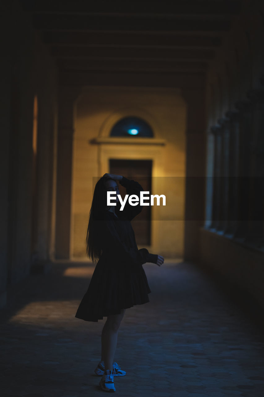 Woman walking in corridor of building