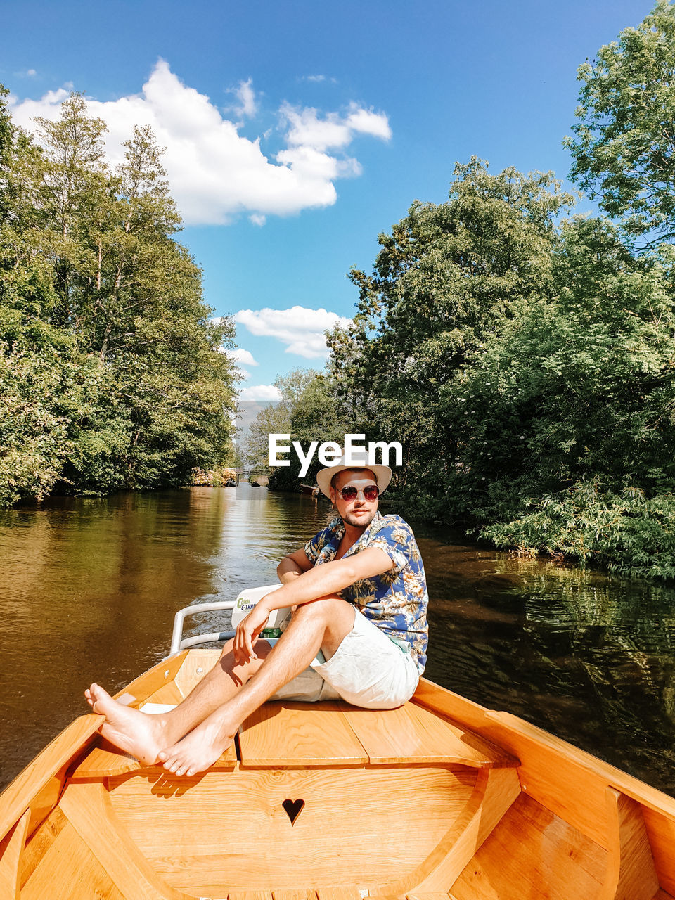 Smiling man sitting on boat in lake