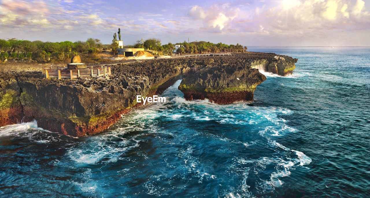 Panoramic shot of rocks in sea against sky