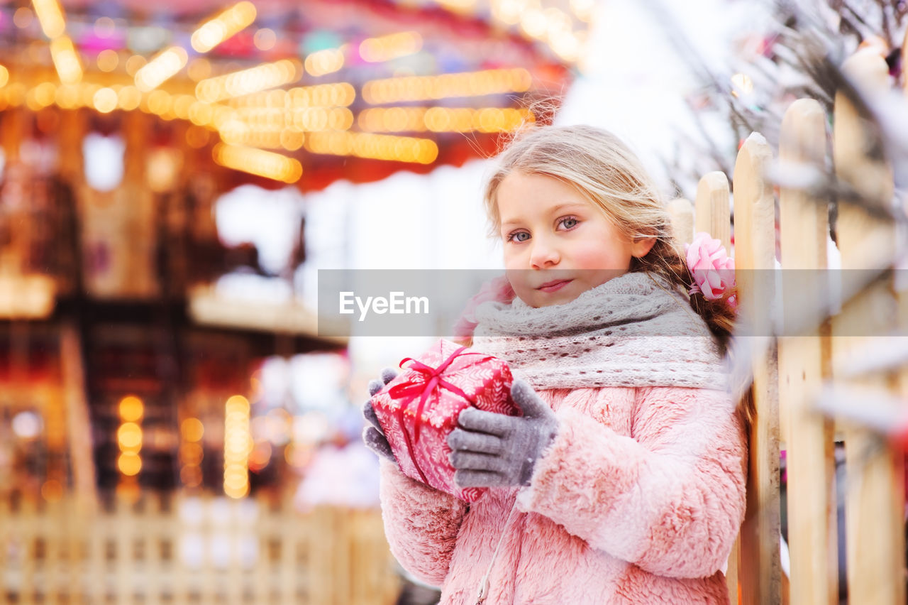 Portrait of cute girl holding gift during christmas