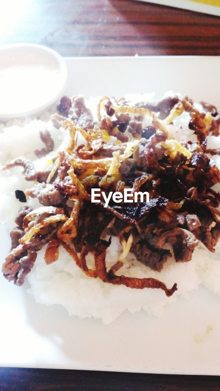 Close-up of fried onions with rice served on table