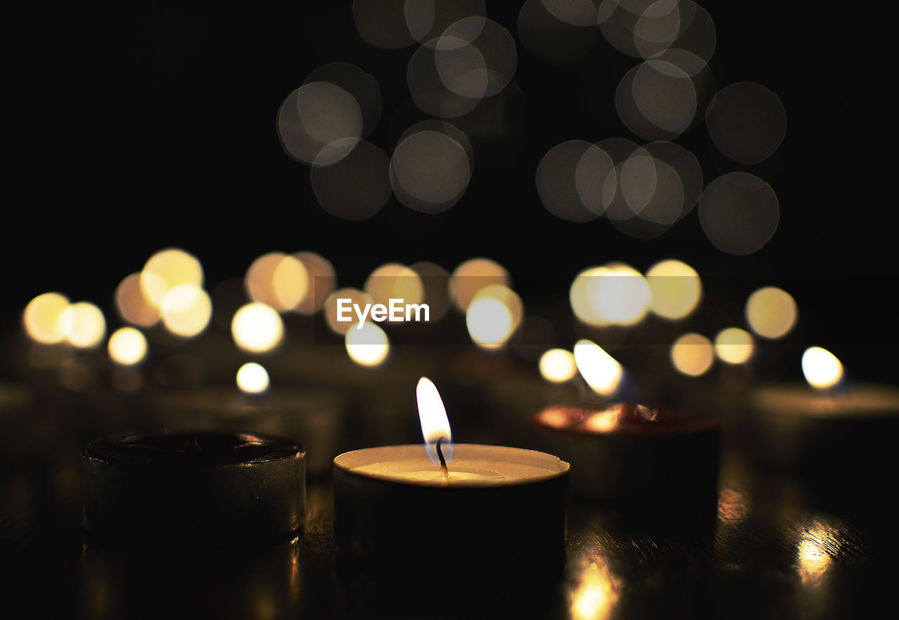 Close-up of tea light candles in darkroom