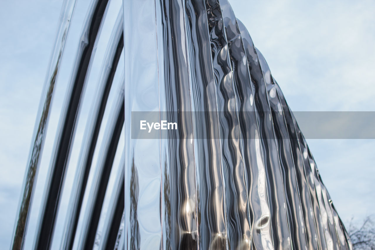 LOW ANGLE VIEW OF GLASS BUILDING AGAINST SKY