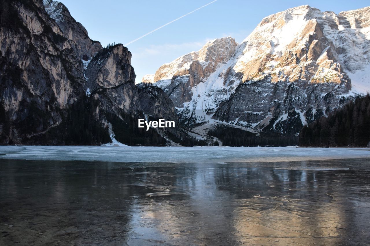 Scenic of frozen lake with dolomites against sky