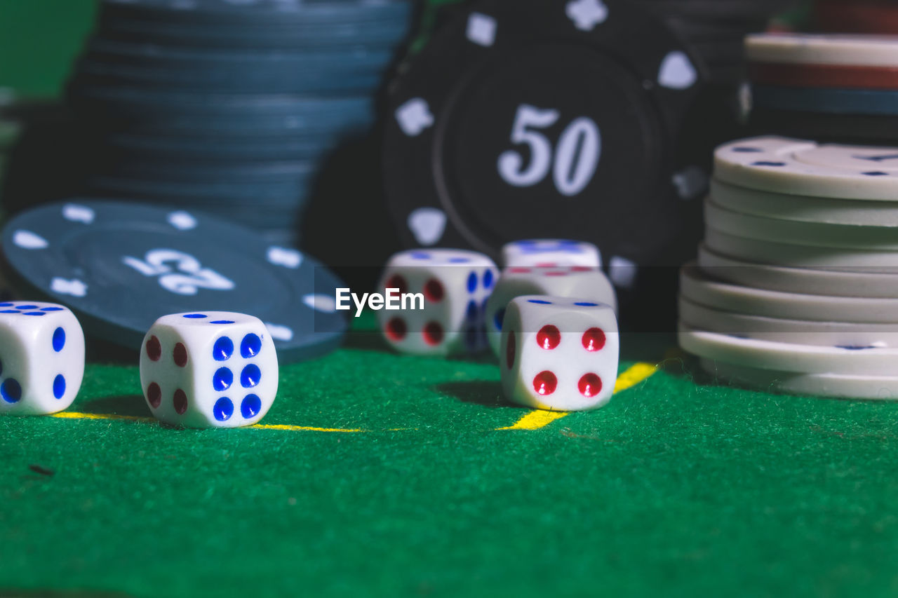 Close-up of gambling chips with dices on table in casino