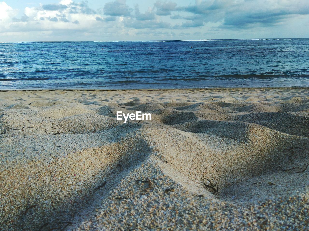 CLOSE-UP OF SHORE AT BEACH AGAINST SKY