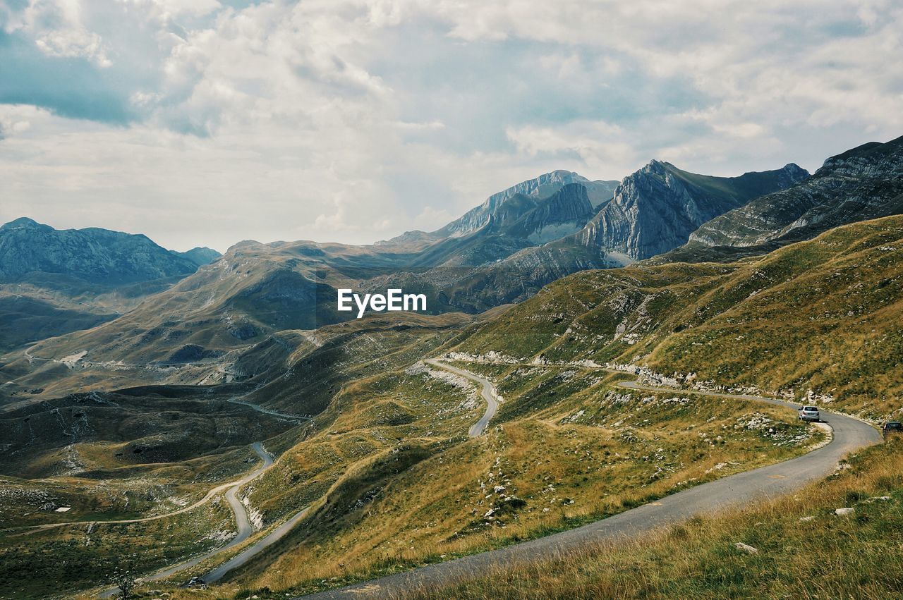 Scenic view of winding mountain road against sky