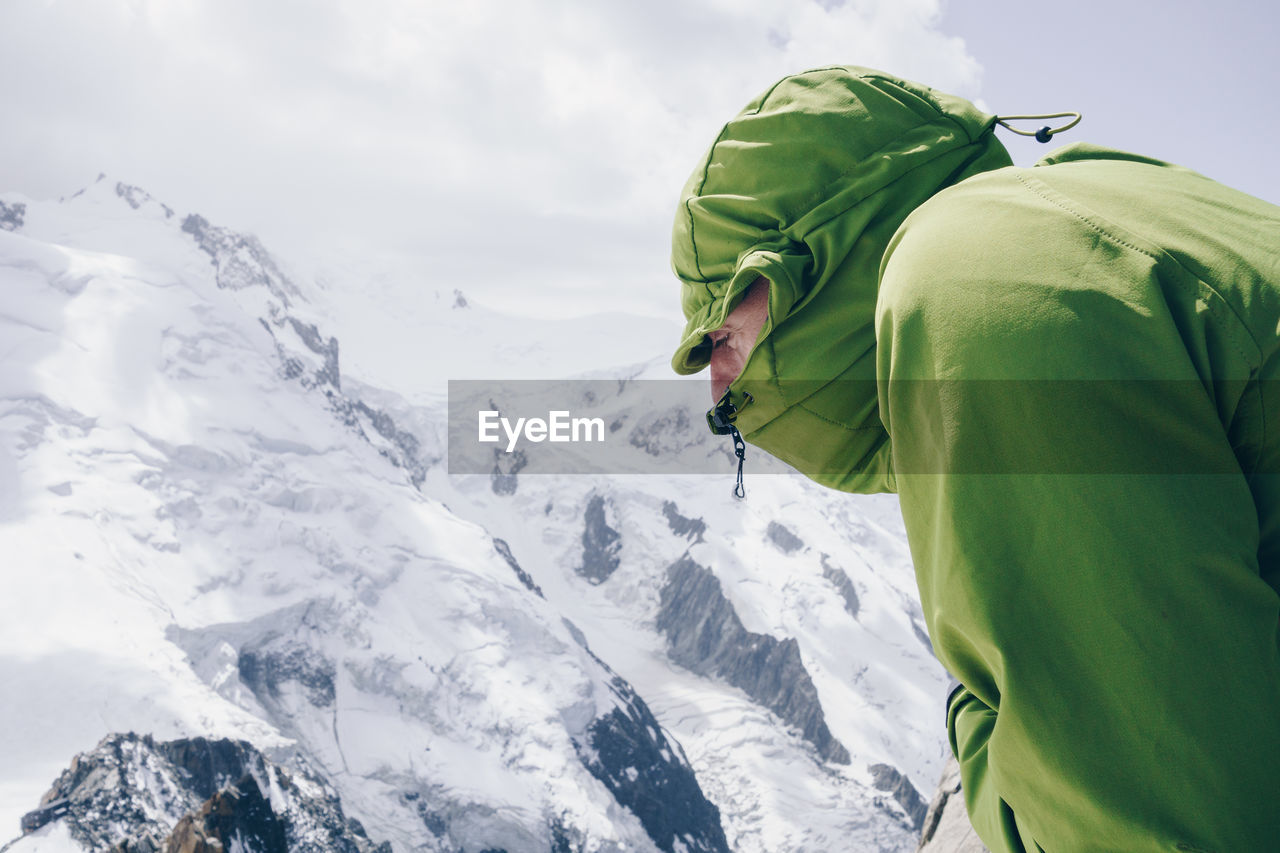 Hiker against snowcapped mountain against sky