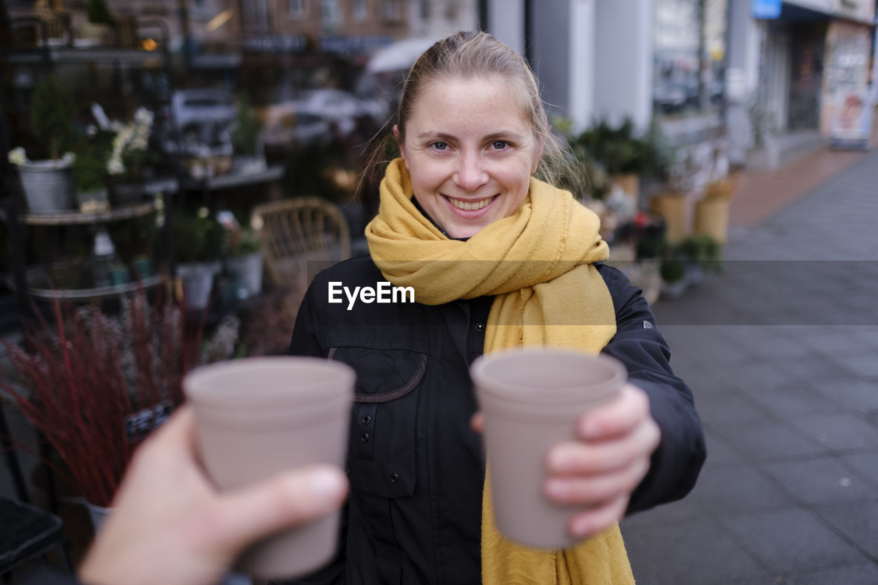 Portrait of a smiling young woman holding drink