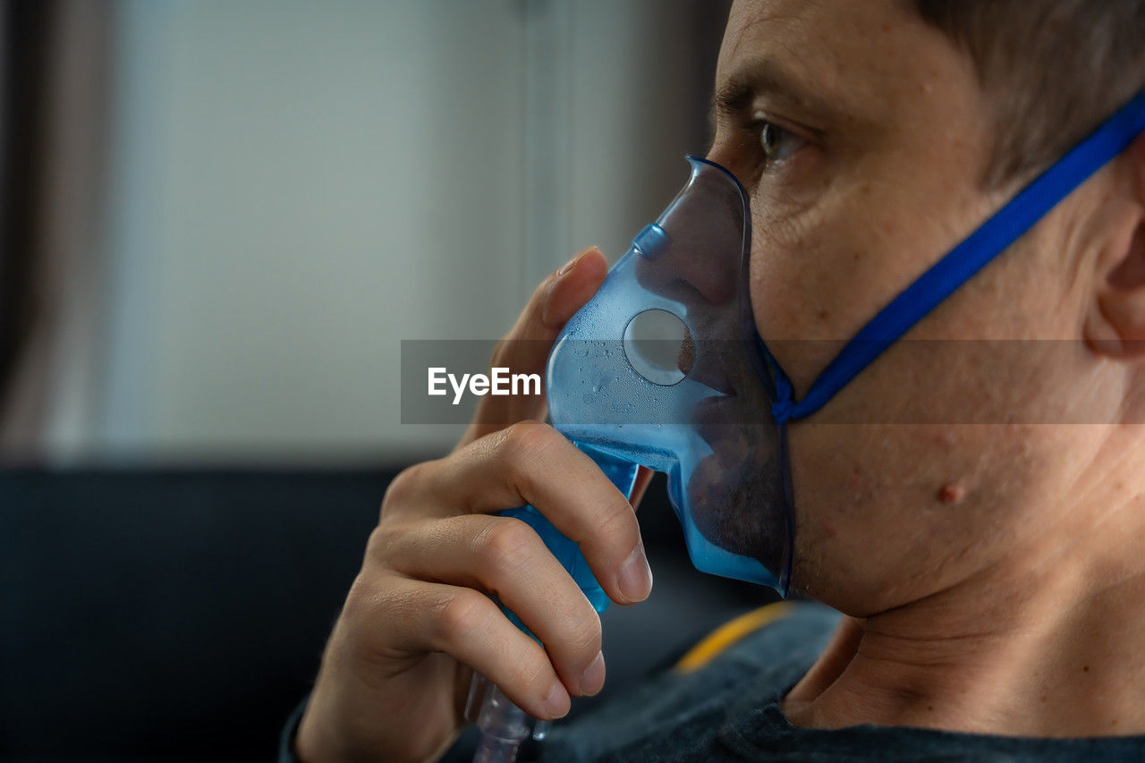 close-up of man drinking water in bathroom