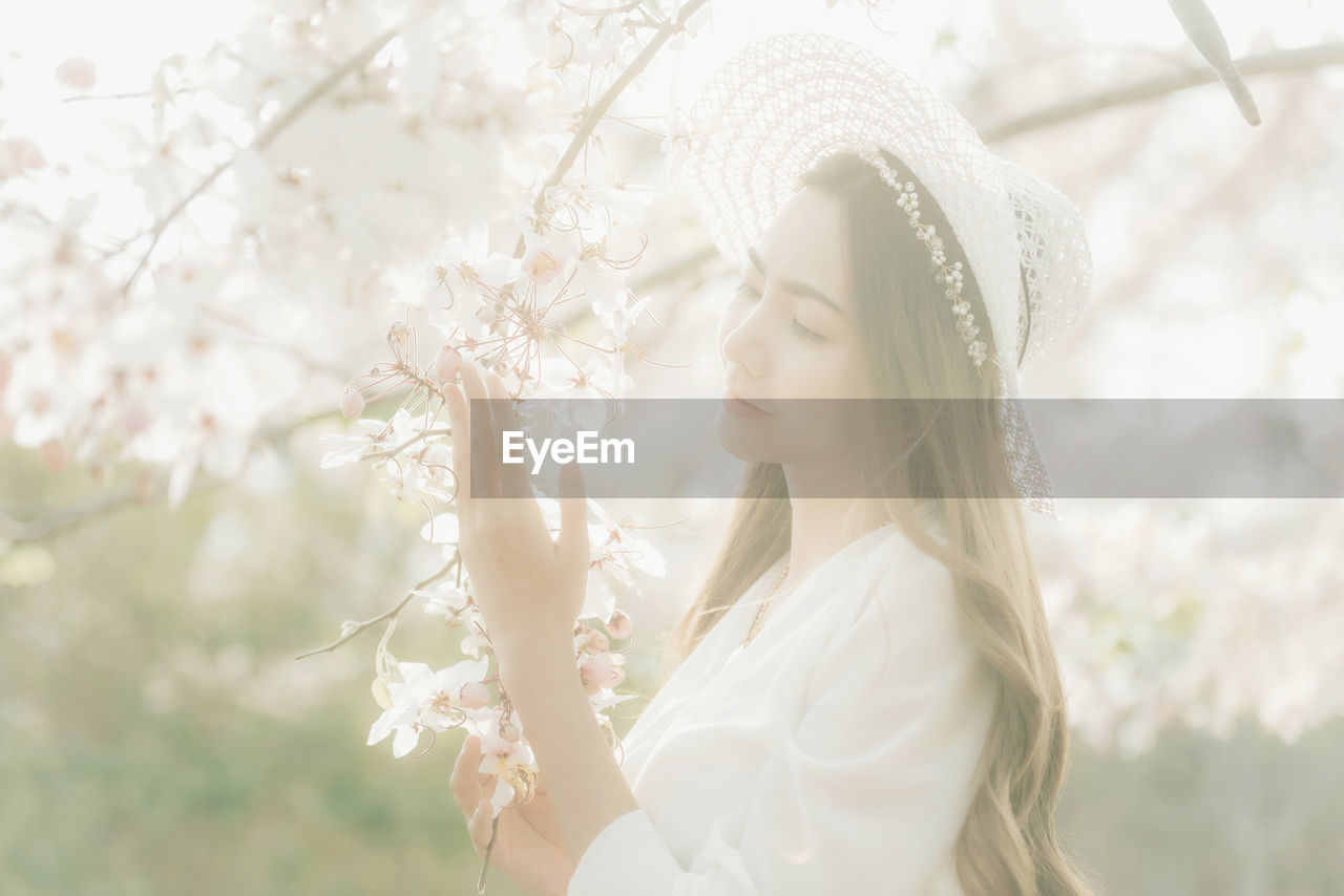 CLOSE-UP OF BEAUTIFUL WOMAN WITH RED FLOWER