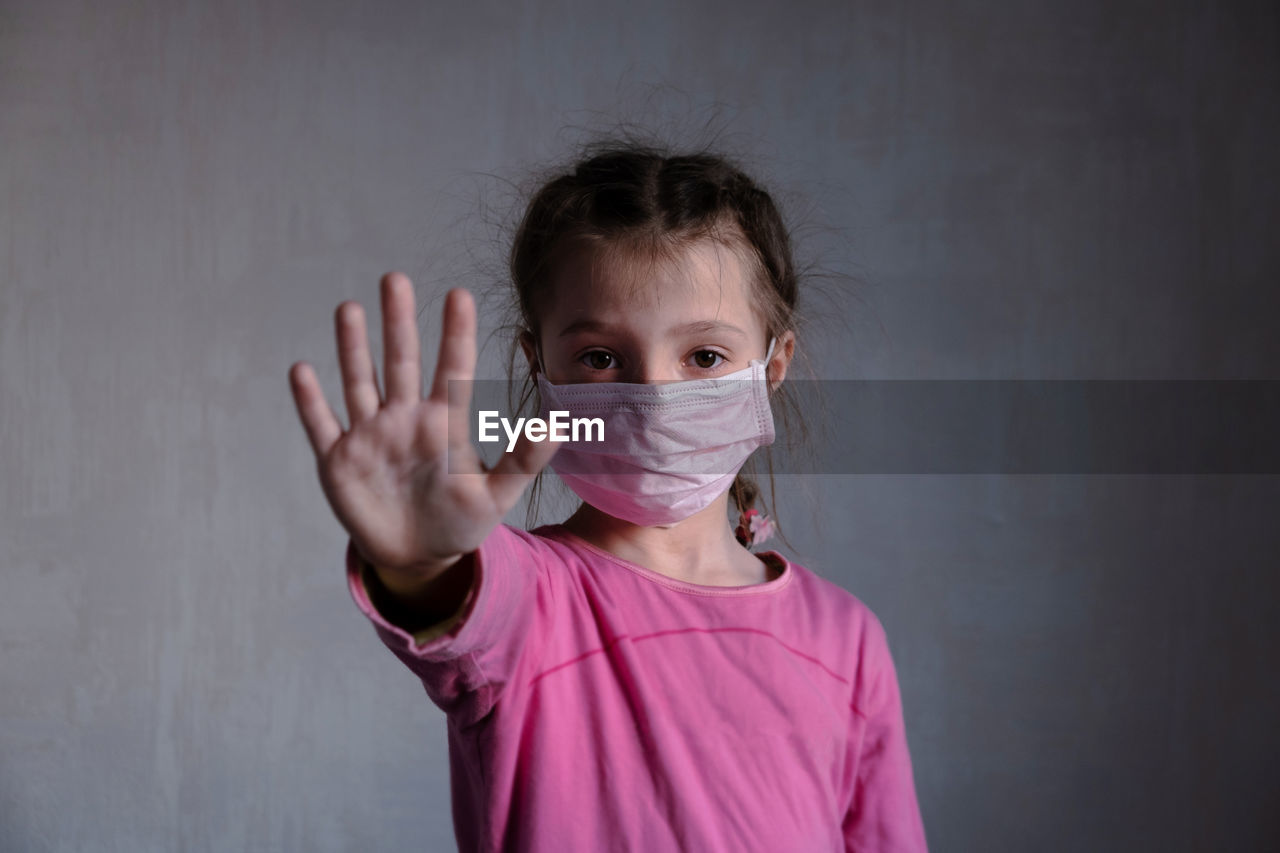 Little girl in mask show stop hand. face in protection mask. stop coronavirus