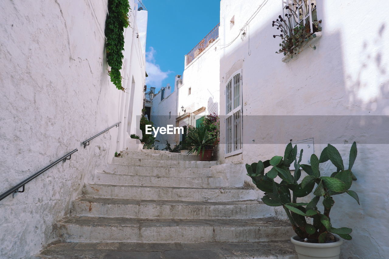 Low angle view of steps amidst buildings against sky