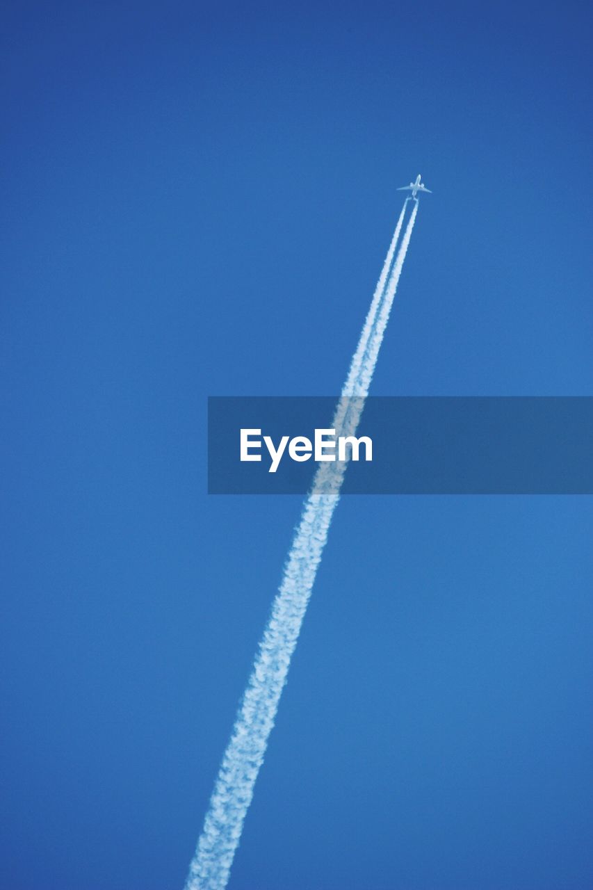 LOW ANGLE VIEW OF AIRPLANE FLYING AGAINST BLUE SKY