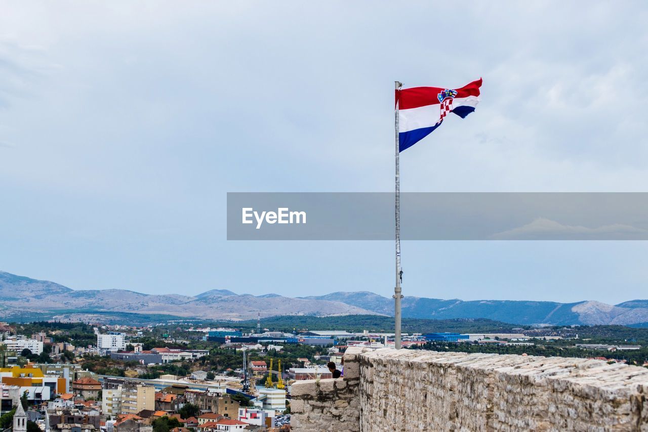 FLAG AND MOUNTAINS AGAINST SKY