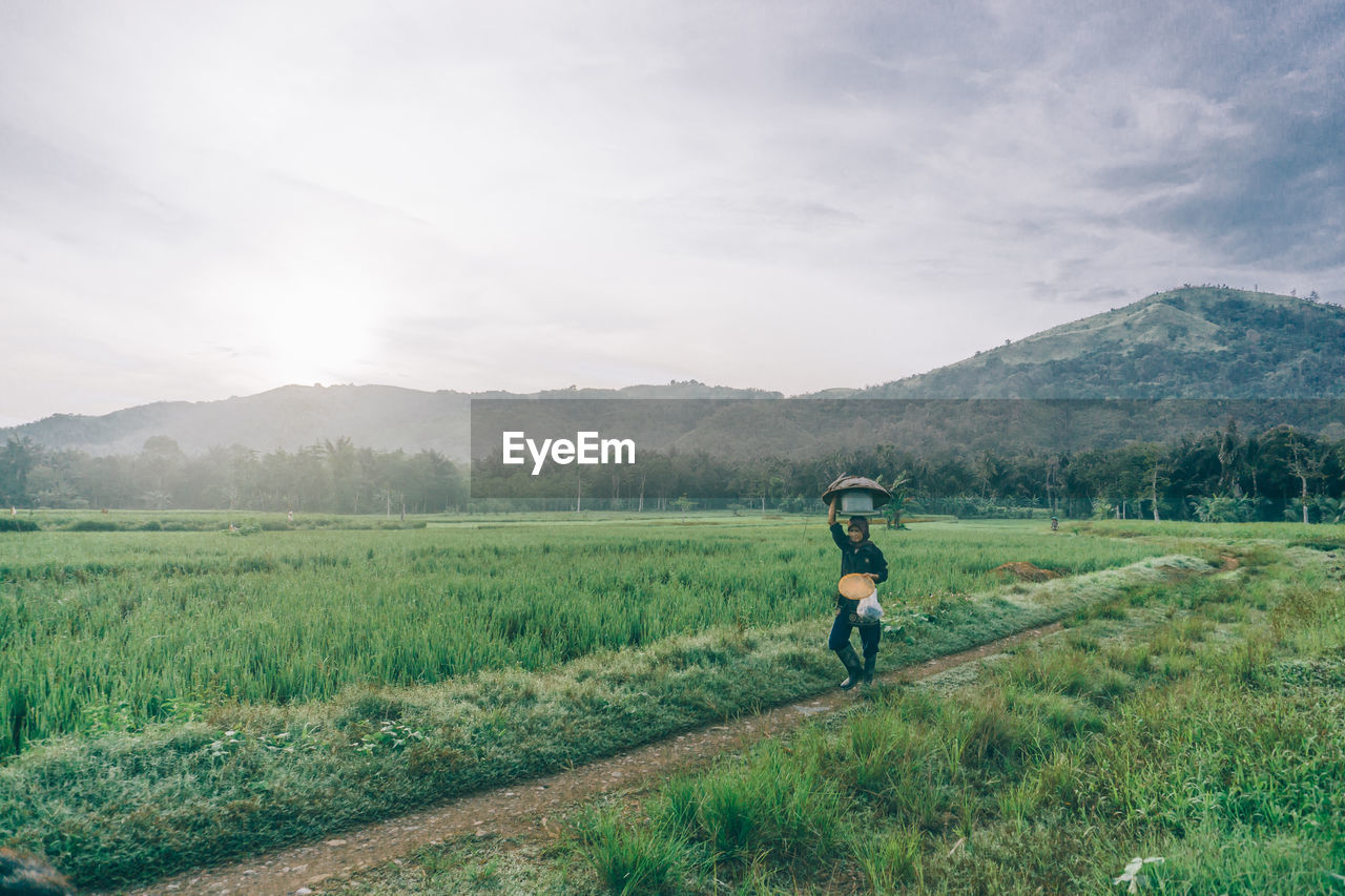 Man working on field against sky