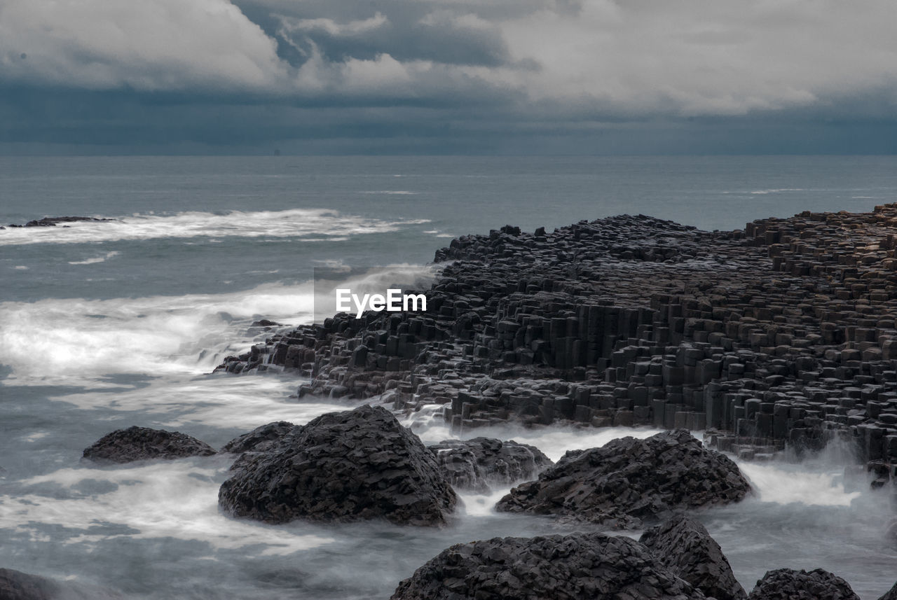 View of rocky beach against clouds