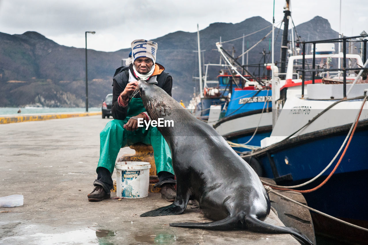 Man with seal by marina