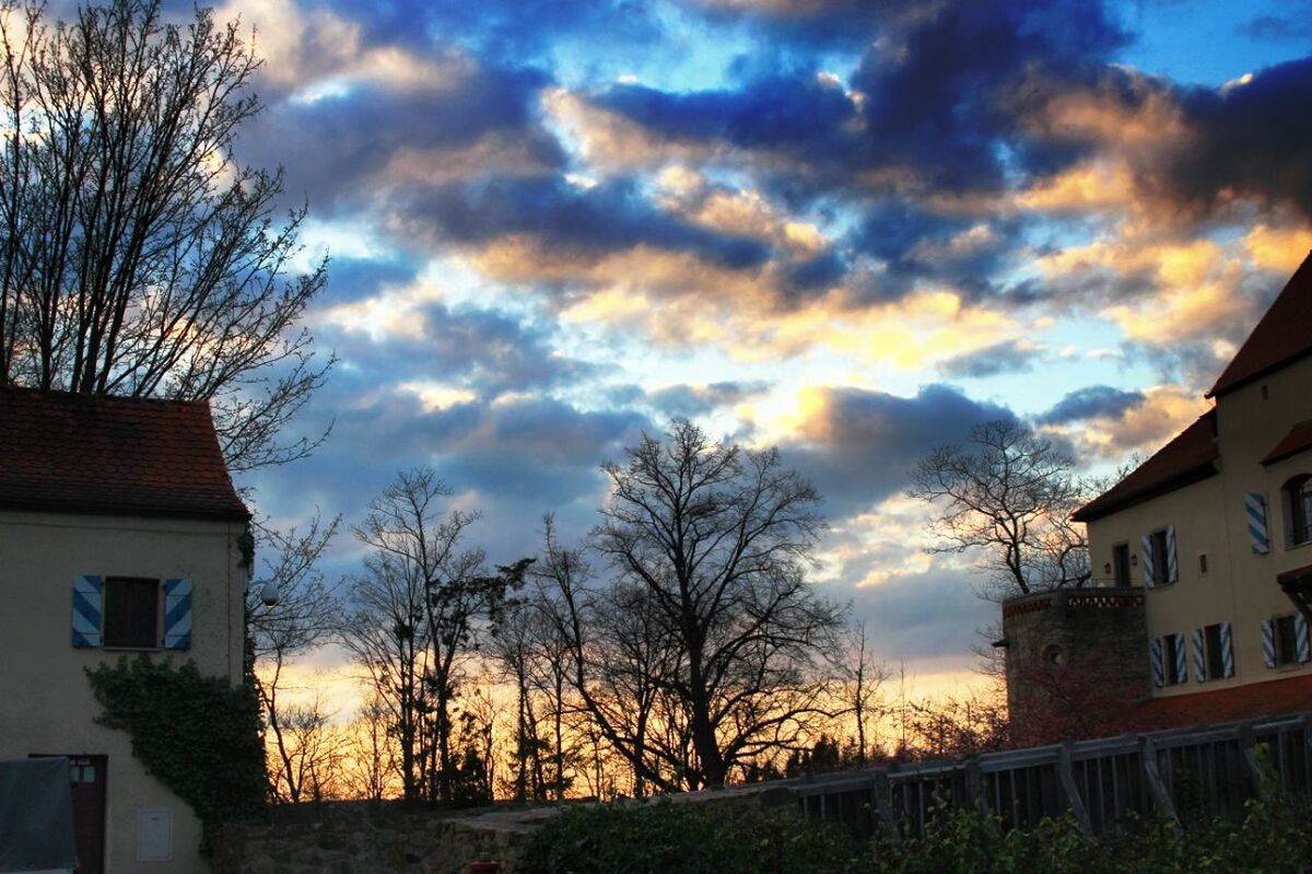 VIEW OF HOUSES AGAINST CLOUDY SKY