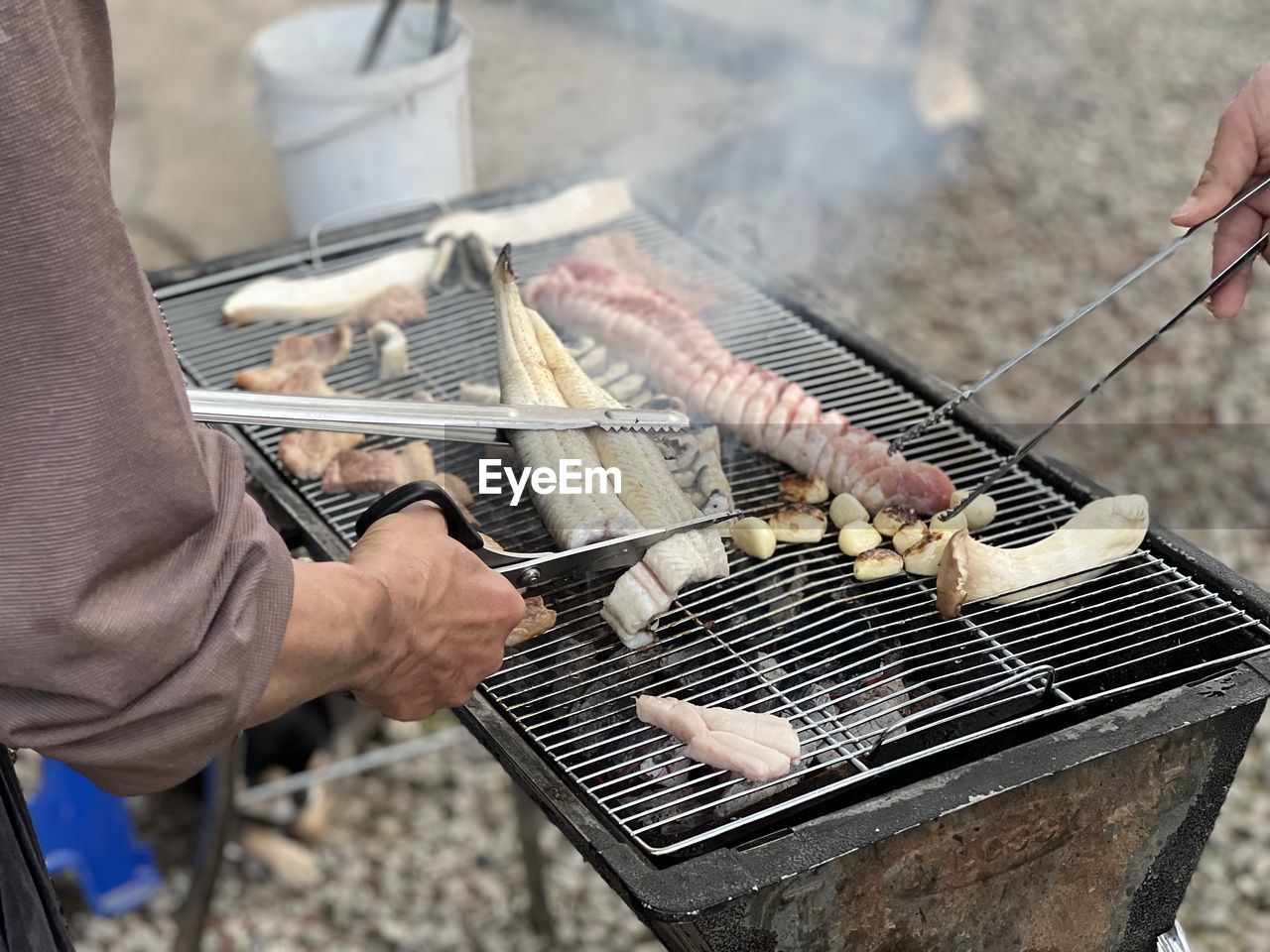 midsection of man preparing food on barbecue grill