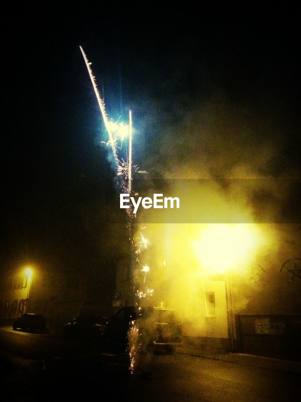 Firework display over buildings against clear sky at night