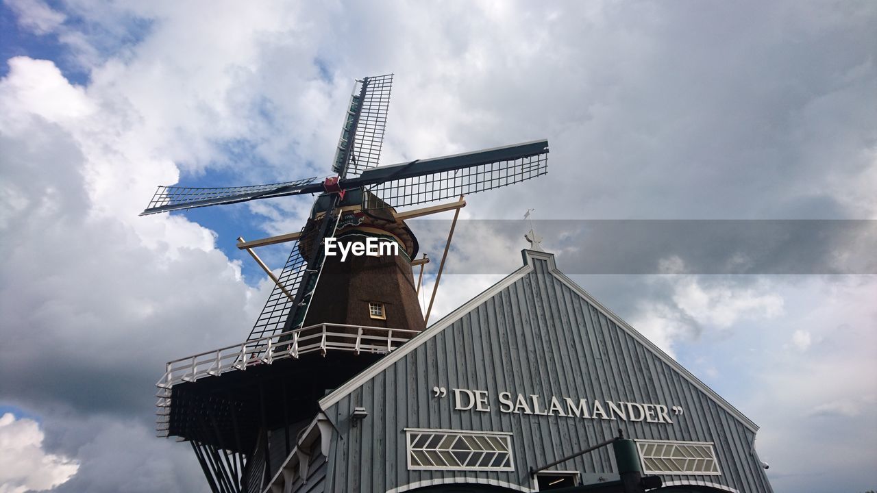 LOW ANGLE VIEW OF TRADITIONAL WINDMILL AGAINST CLOUDY SKY