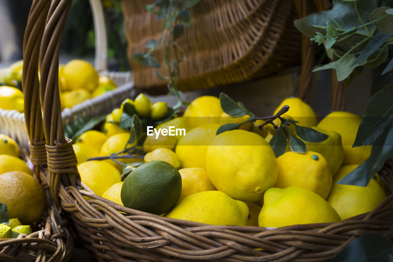basket, food, food and drink, yellow, healthy eating, fruit, container, citrus, freshness, plant, citrus fruit, wellbeing, wicker, lemon, produce, orange, abundance, no people, green, large group of objects, organic, agriculture, nature, outdoors, flower, retail, market, citron, still life, close-up, leaf