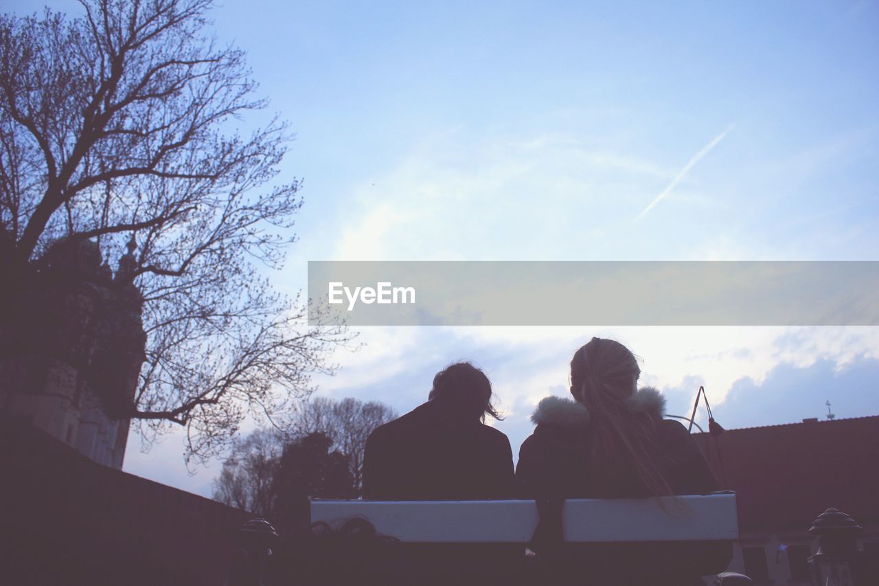 Low angle view of women sitting on bench