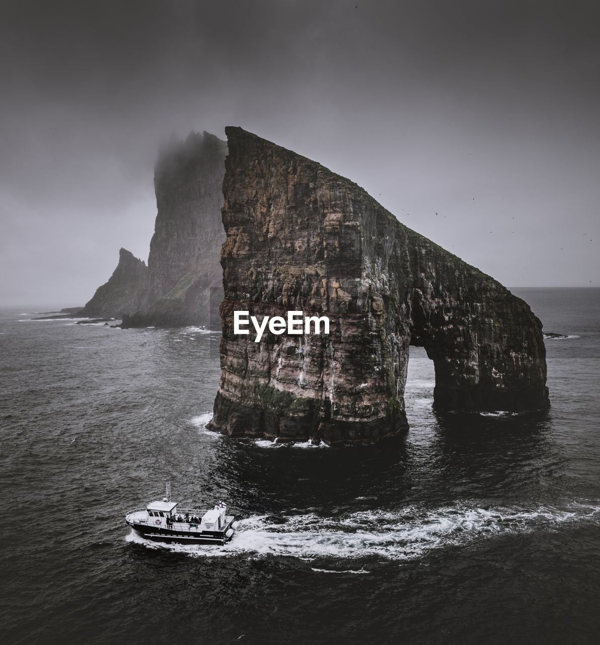 Scenic view of rock formation in sea against sky