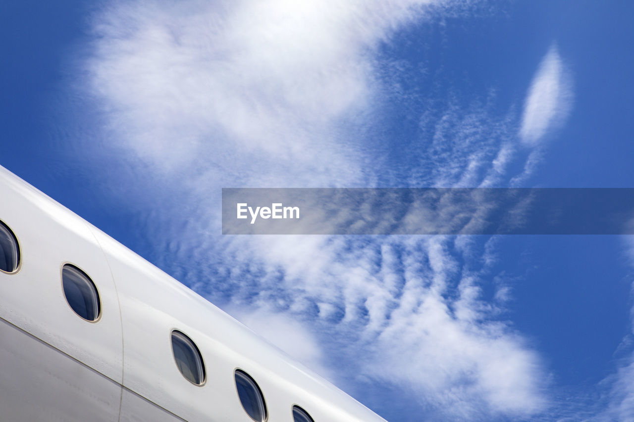 Fuselage of jet airplane against blue cloudy skies